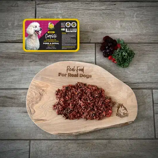 Prodog Raw dog food on a chopping board next to the new Pork & Offal Complete meal container